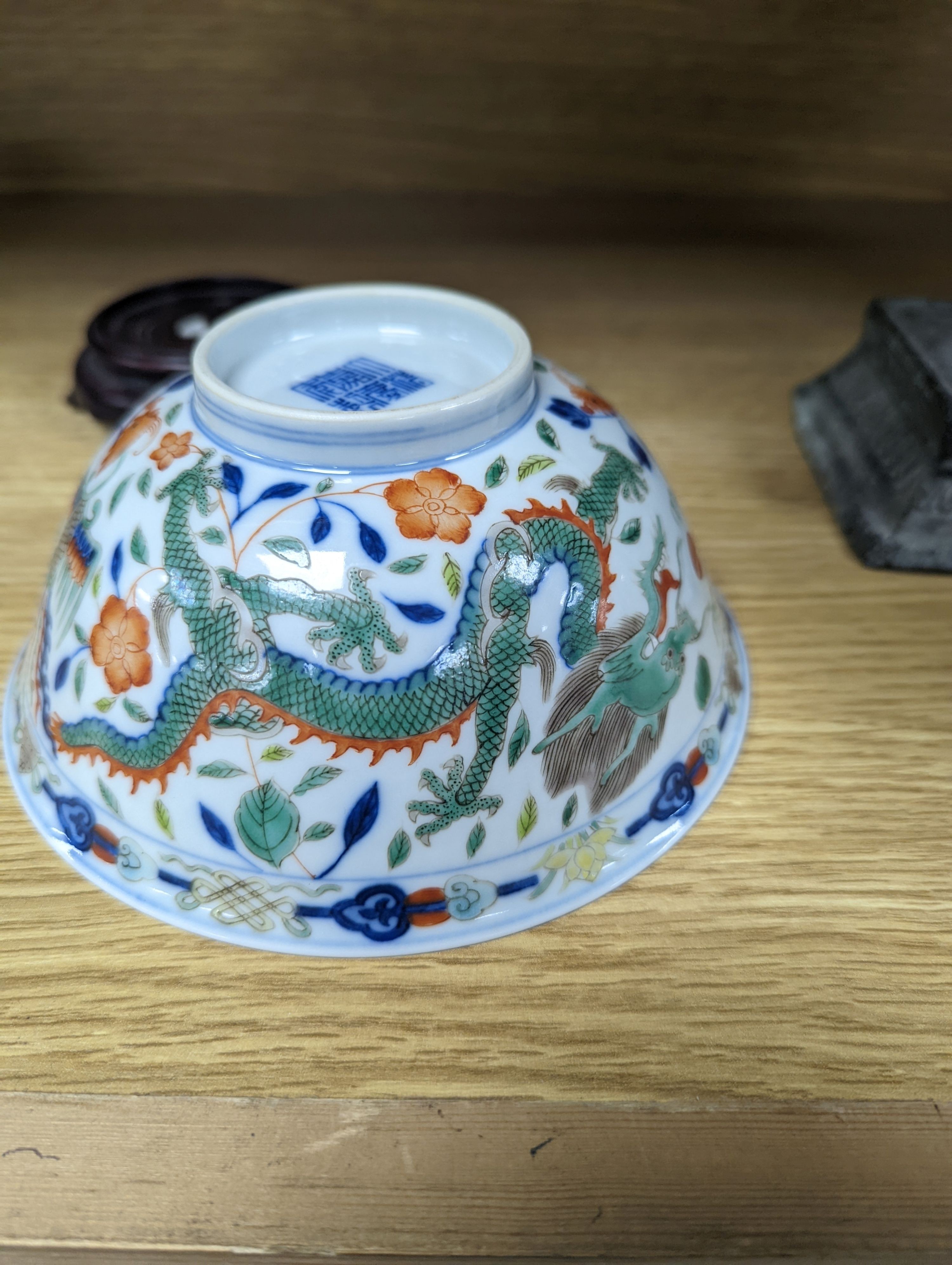 A Wucai bowl, dragon and flamingo pearl decoration, Jiaqing mark, on wood stand. 16cm diameter